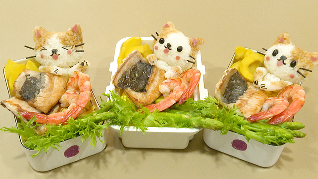 Her kids love cats, so she makes rice balls in the shape of kitty cats. They’re modeled after her sons! Each cat has different features, but they're all holding their favorite food—fish! It's a fun and delicious kitty cat milkfish bento!