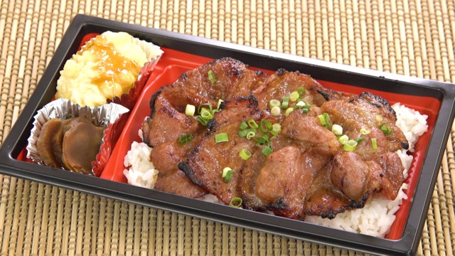 The local specialty bento features rice topped with slices of miso marinated pork steak. It’s a Miso Pork Bento.