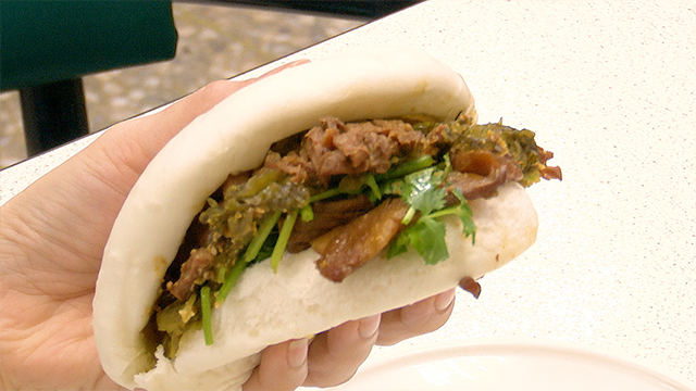 Gua bao is a Taiwanese pork burger featuring fluffy steamed buns stuffed with tender braised pork belly, pickled mustard greens, peanut powder, and cilantro. The half-moon shape of the bao buns resembles a money pouch, which is why eating bao has been thought to bring good luck since ancient times.