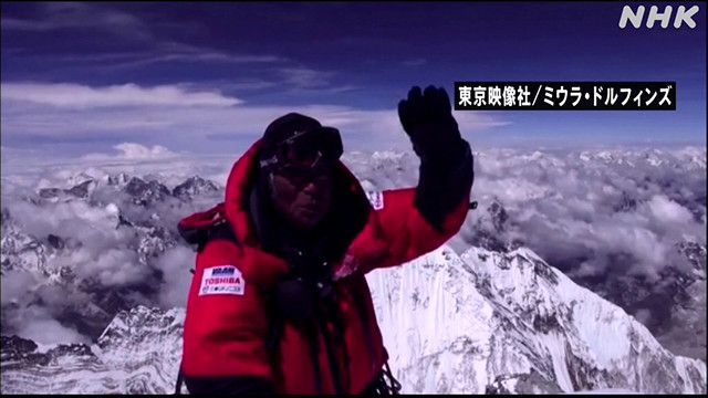 エベレスト山頂で手を振る