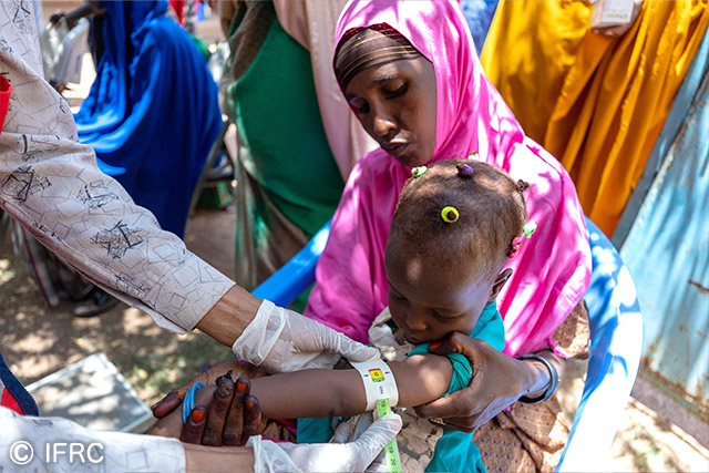 アフリカ食糧危機への支援（ソマリアで子どもの栄養失調状態をチェックする赤十字ボランティア）