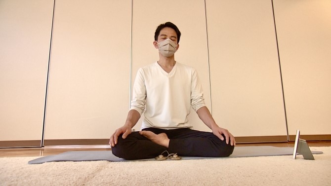 長谷川さんがマインドフルネスの瞑想（めいそう）を行っているところ