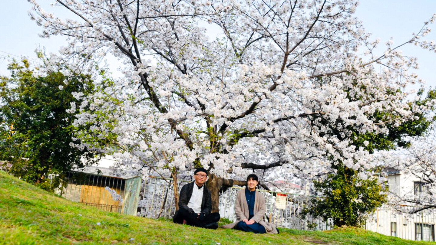 桜の前に座るシニさんとまりえさん