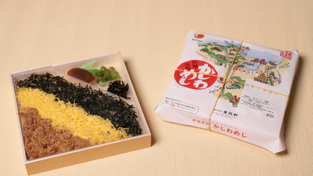 The ekiben he sells is a Kashiwameshi bento. Kashiwameshi is rice cooked with chicken, a specialty of this region. The bento rice is cooked in chicken soup and is topped with savory chicken, shredded egg omelet, and nori.