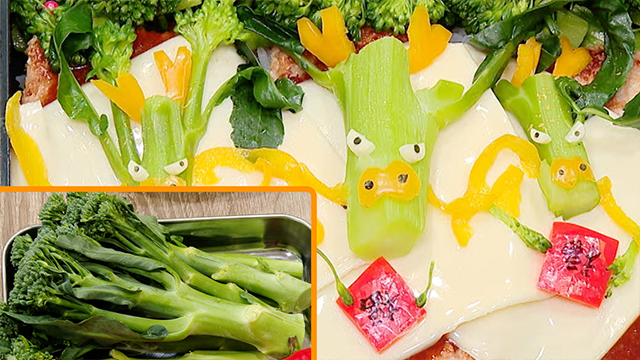 After topping the "steaks" with cheese, she cuts off the florets from broccolini, leaving only the lower stems and leaves. She then makes the dragon decorations with nori, yellow bell pepper, and cheese. She also adds New Year decorations made from red bell pepper and edible ink.