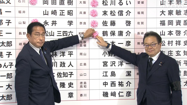 当選者の名前に花を付ける岸田首相