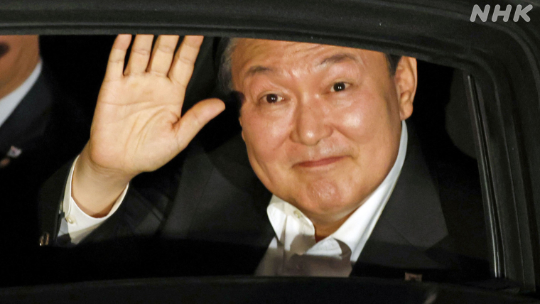 写真：車内で手を挙げるユン大統領