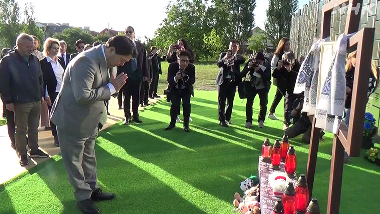 ブチャで林大臣がモニュメントに花を手向け、祈りをささげている様子。